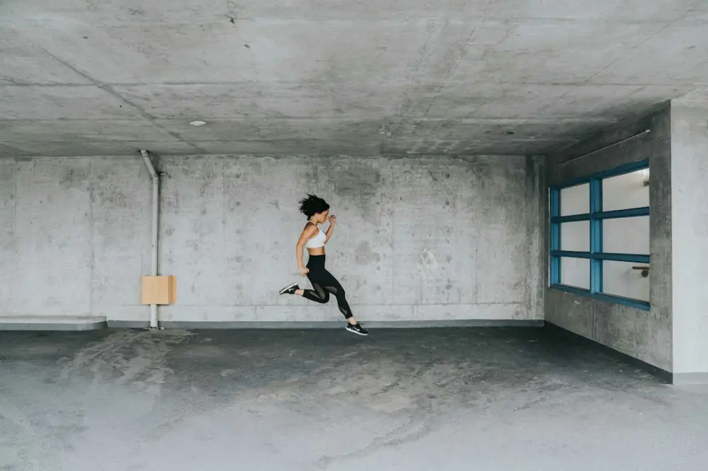 Jumping woman inside building, illustrating building manageable motivation routines